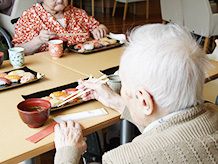 入居者様がお寿司を召し上がる風景。一貫が半分に切ってあり、ご自身で召し上がりやすいよう工夫されている。