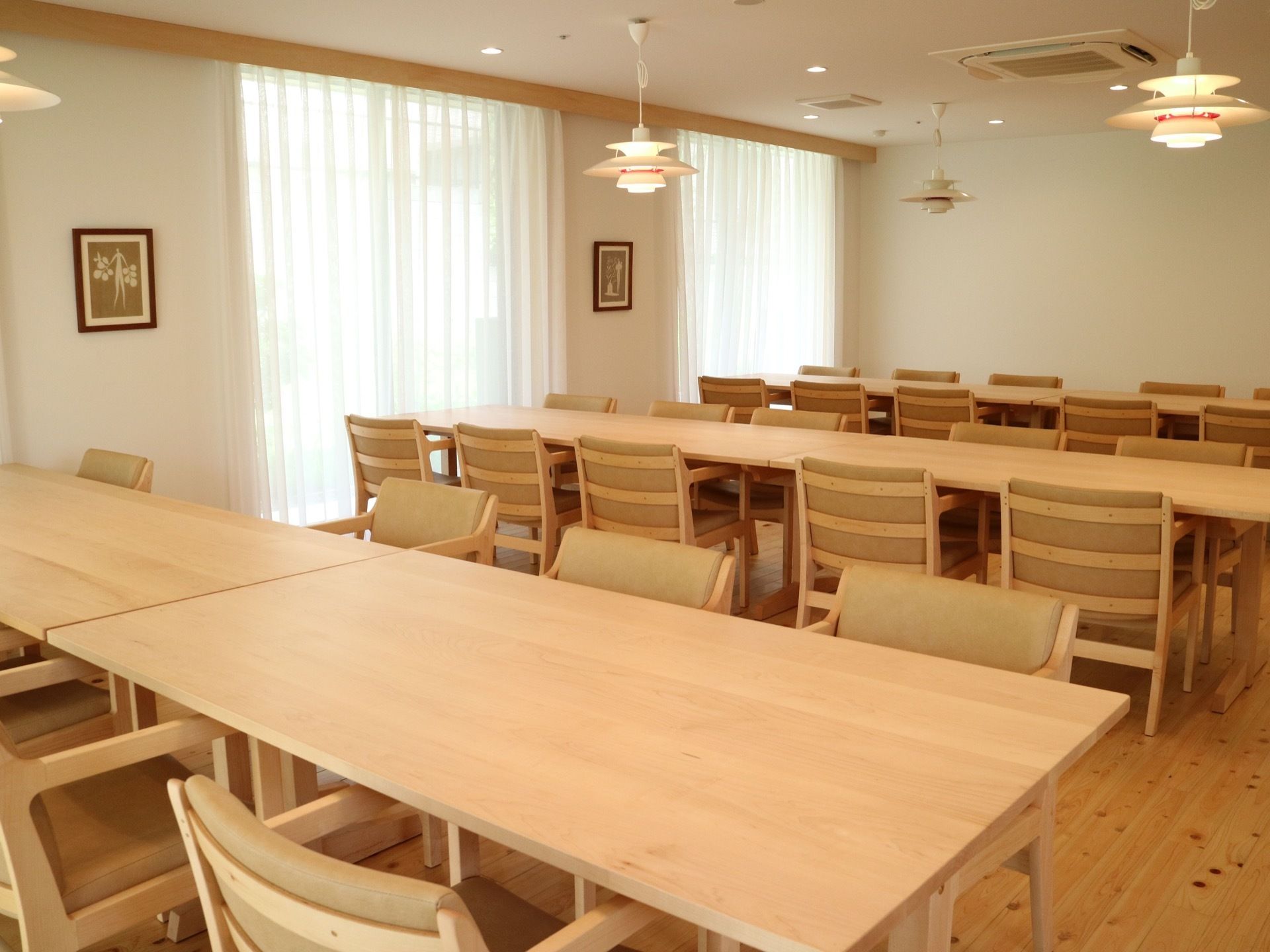 大きな窓のある広い部屋に、木製のテーブルセットが整然と並んでいる。照明はおしゃれで空調も整っている。