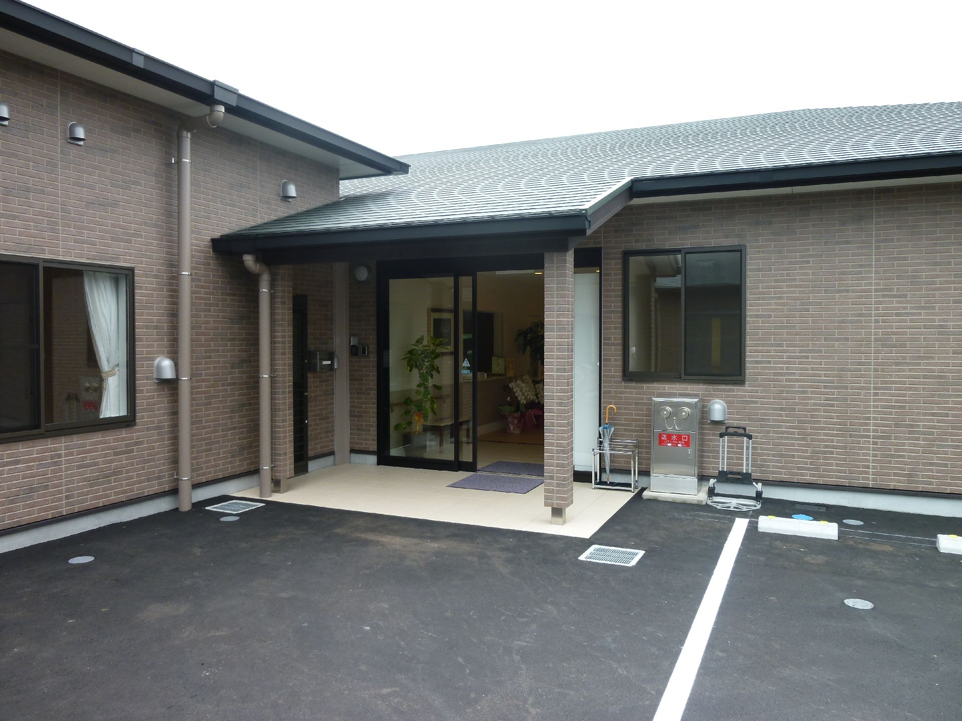 玄関はフラット設計なので、足腰に不安のある方や車椅子をご利用の方でも楽に行き来できる。屋根がひさし代わりになっている。