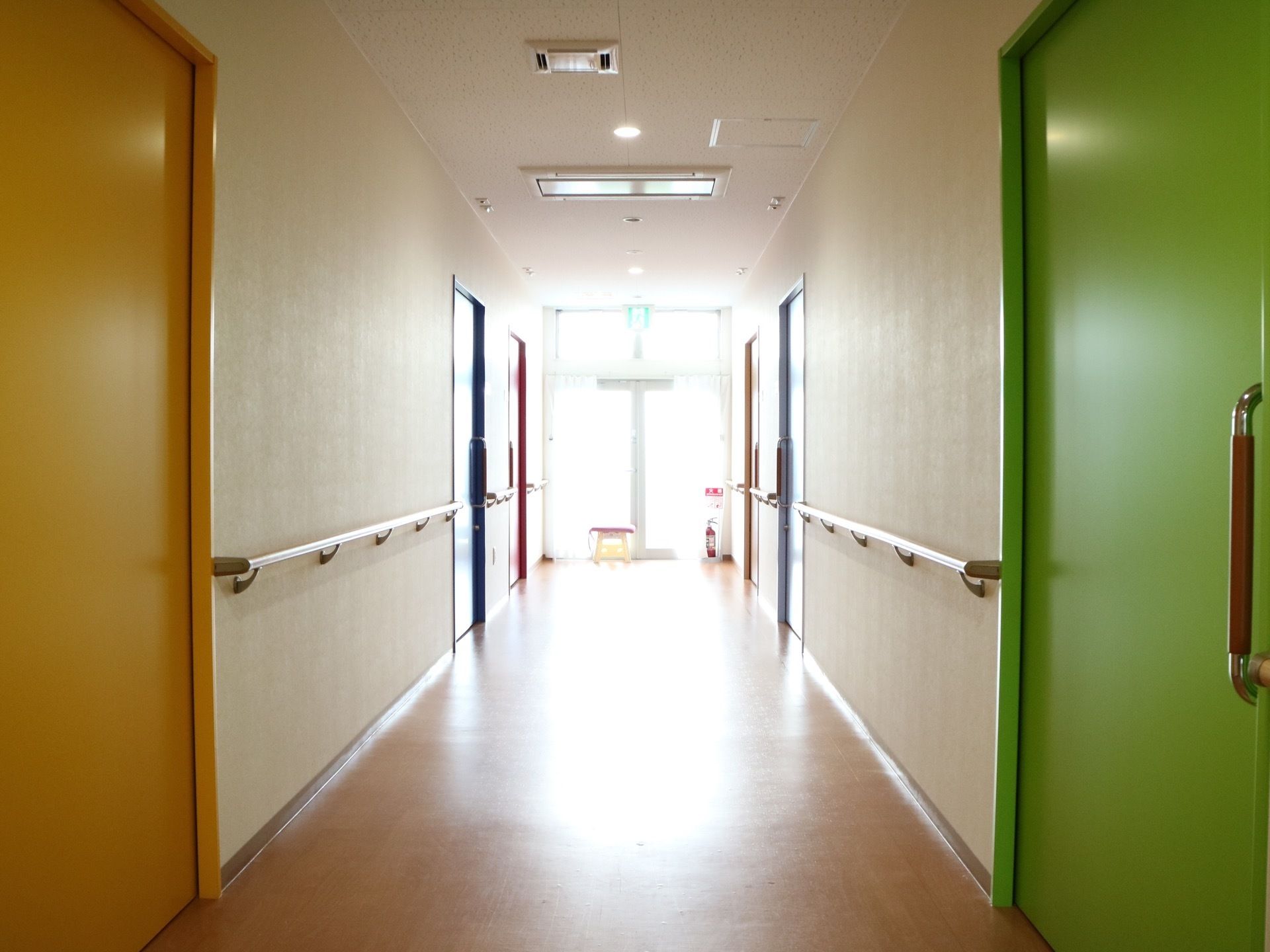 通路には手すりを備え、スムーズに歩行できるようにしている。各部屋の扉の色を変え、部屋が分りやすいように工夫をしている。