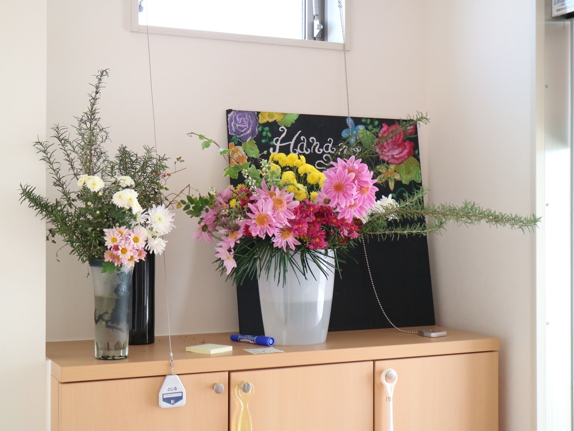玄関にはシューズボックスが備わっており、その上には花瓶に生けられた花が置かれ、チョークアートが飾られている。