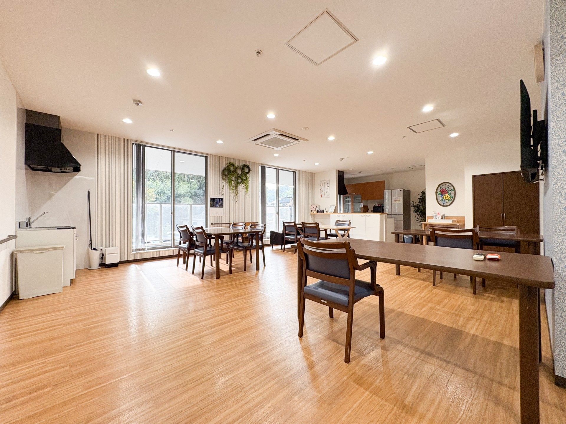 大きな窓からは明るい日差しが降り注いでいる。濃いピンクのキッチンと左手には車いす対応の洗面所がある。