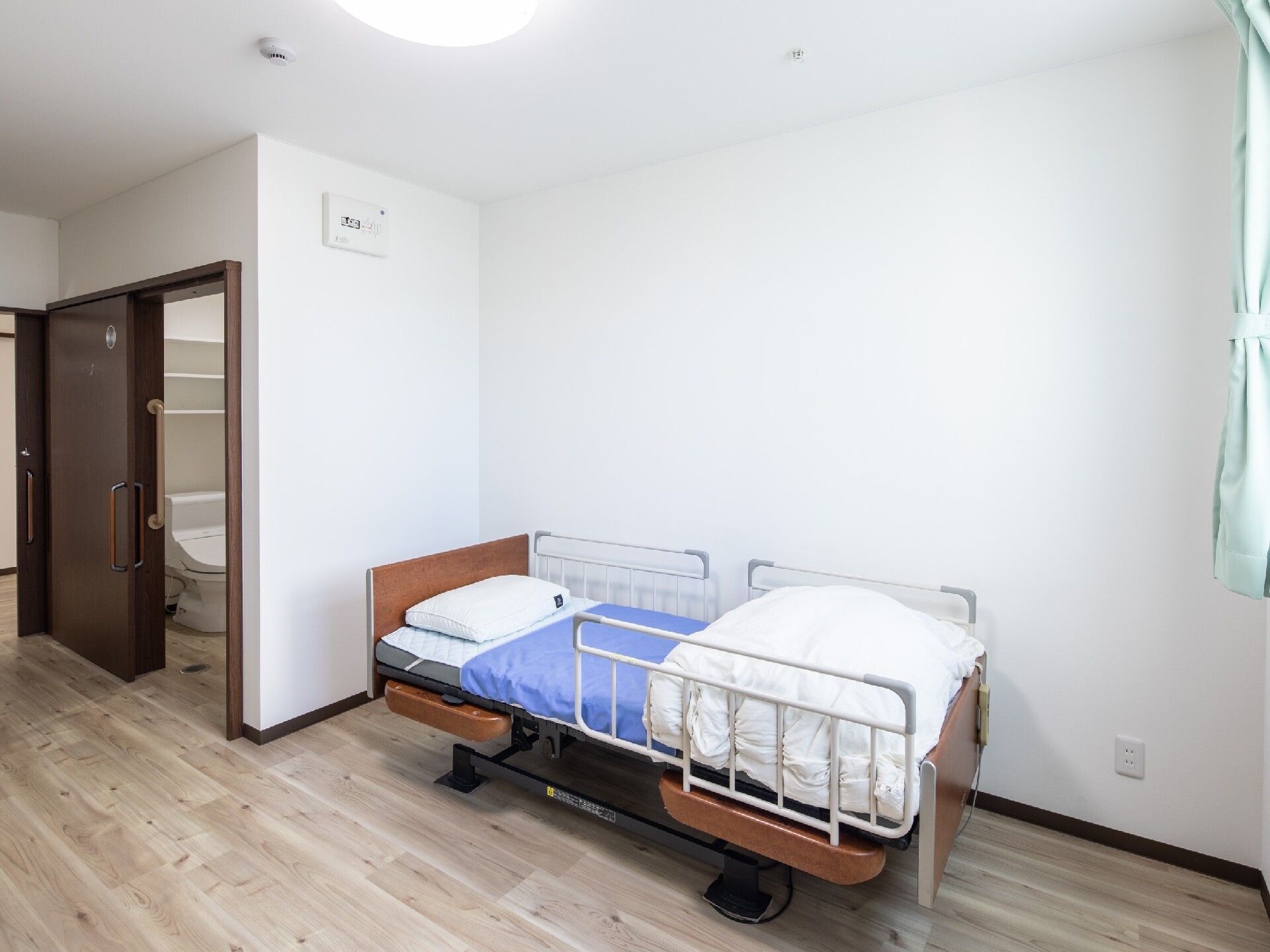 居室は段差がなくシンプルなワンルームタイプ。エアコンやキッチンが付き、家具は持ち込み制。