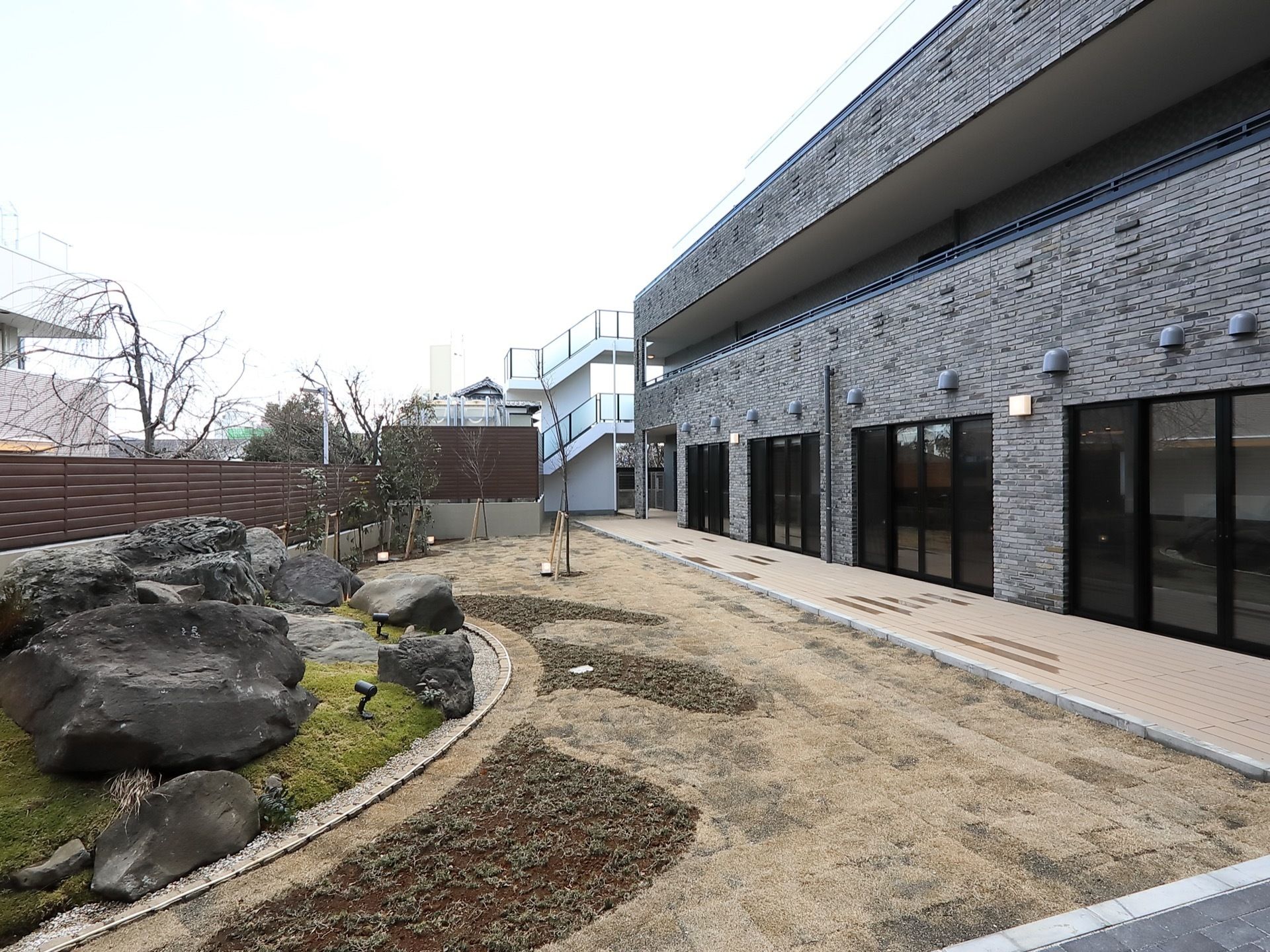 敷地内の庭の様子である。さまざまな種類の岩を取り囲むように、芝生、遊歩道がある。周囲に高い建物がなく陽当たりが良い。