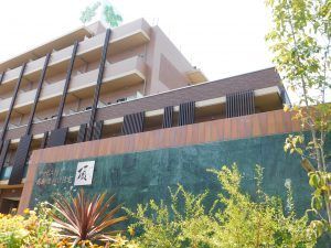 住宅完成図のスケッチ。鉄筋コンクリートでできた5階建ての建物の周辺には緑の木が植えられている。