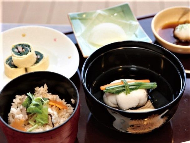 炊き込みご飯・吸い物・具入りの出汁巻き卵など5品が美しく並べられたトレイ。