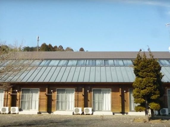 建物前に木が立っており、斜めの屋根をした平屋建て施設