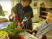 テーブルの上に置かれている水盤に生け花をする入居者様