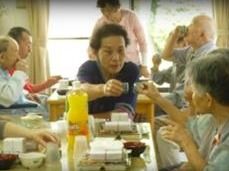 飲み物や食事が並んでいるテーブルにつき、乾杯をしている二人の入居者様