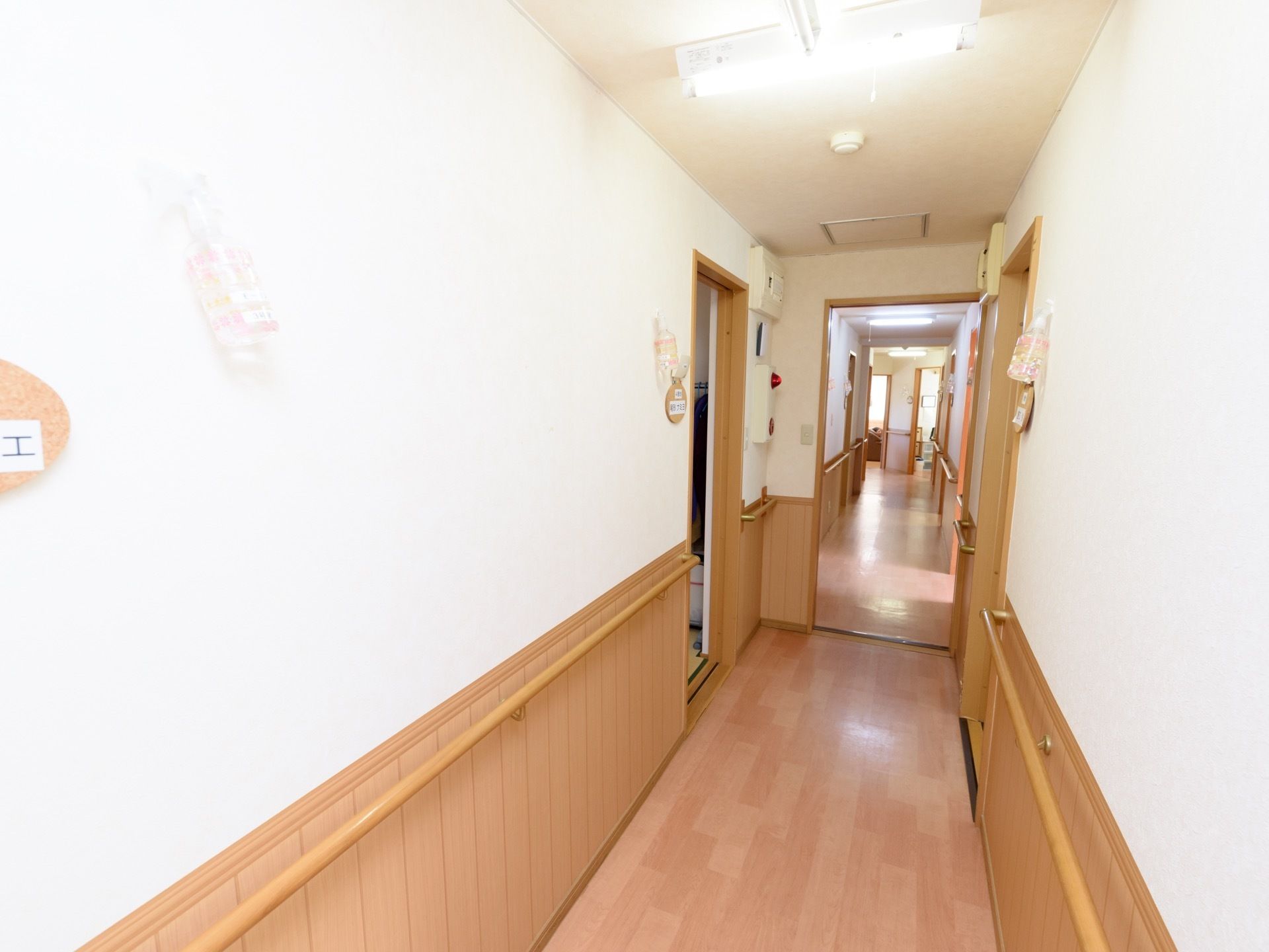 共用廊下のすべての壁の腰高あたりには木製の手すりが設置されており、入居者様が通行する際には転倒の心配がなく安全である。