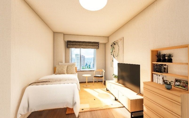 壁や家具などを白で統一し、清潔感のある居室である。ベッドやソファー、机などを設置しても十分な広さがある。