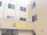 住宅型ホームの外観。淡い色合いなので圧迫感がない。日当たりが良さそうな建物がたたずんでいる様子。住宅街の中。