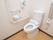 手すりとナースコールを備えたトイレである。可動タイプの手すりは用途に応じて利用することができ、便利である。