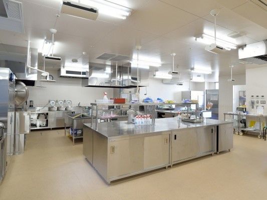 ステンレス製のキッチン用品が並ぶ本格的な厨房の様子。施設内に設置された食事管理用の部屋。