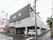 市の中心地に建っていて、周辺には大型店舗や商業ビルが立ち並んでいる。１階の駐車スペースの一部がタクシー乗り場になっている。