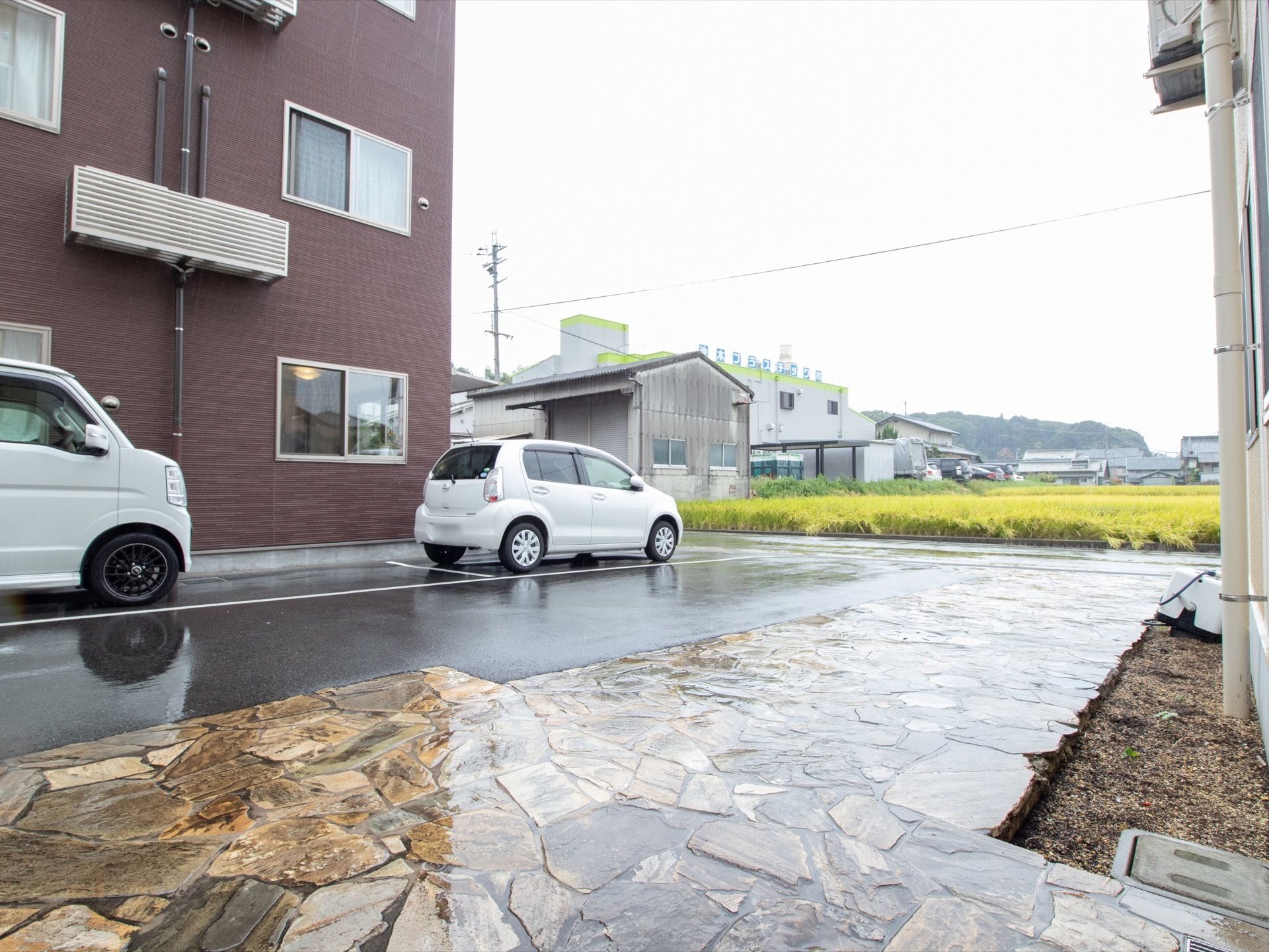 施設建物の前には、石畳が敷いてある。石畳と駐車スペースの境目はフラットに、フェンスもなく開放的である。