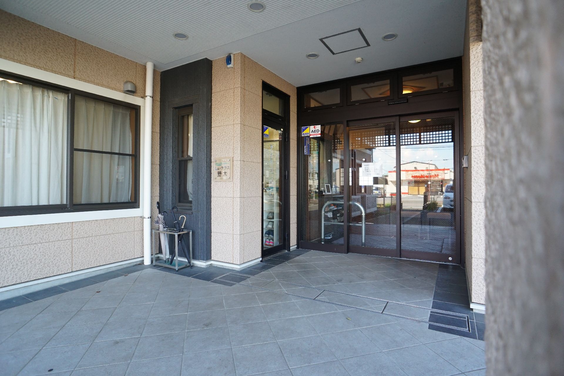 白い壁の建物の屋根が付いた入り口