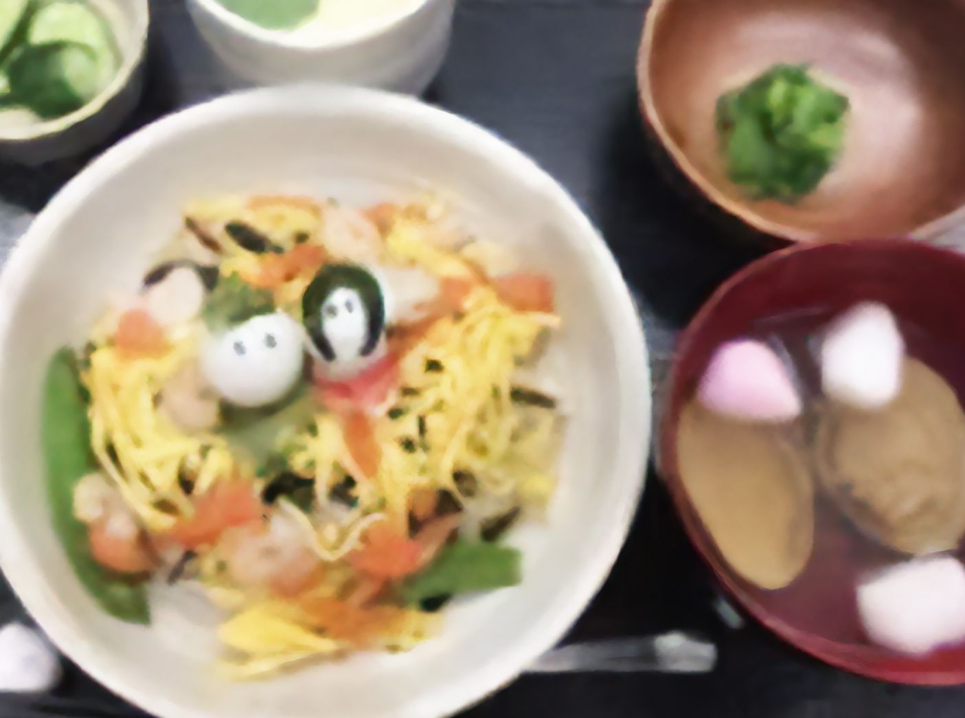 鶉卵で作ったひな人形を中央に置いた散らし寿司や蛤の吸い物といったひな祭り用の食事。