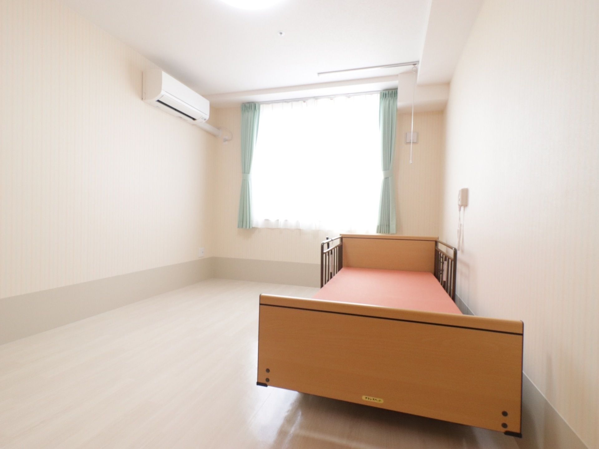 ひとりで部屋でくつろいでいる男性。ホワイトを基調とした部屋で明るい様子が分かる