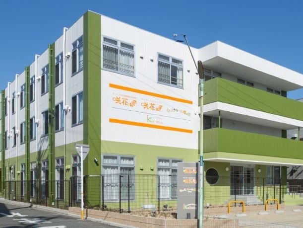 建物内で仕事をしているスタッフ。誰かに目線を合わせ、会話しようとしている。