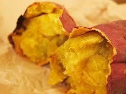 包丁ではなく手で二つに折られたような断面の焼き芋が、茶色の紙の上に置かれている。