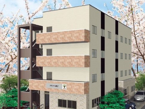 淡い色合いの建物が写っている。数階建ての住まいであることがうかがえる写真