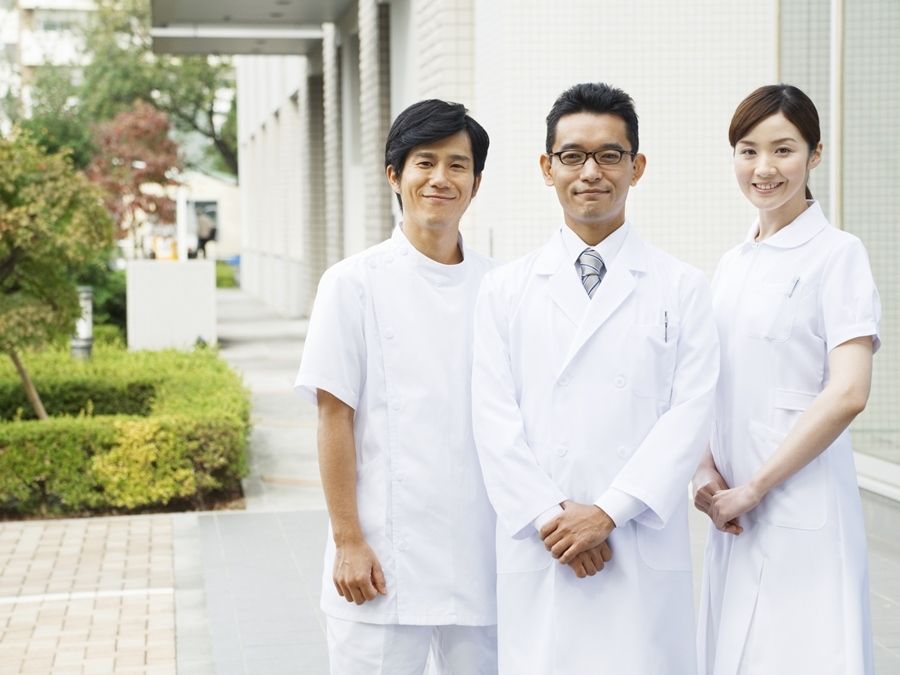 ３人の看護師と医師がこちらを向いて微笑んでいる。すました感じで写っている写真