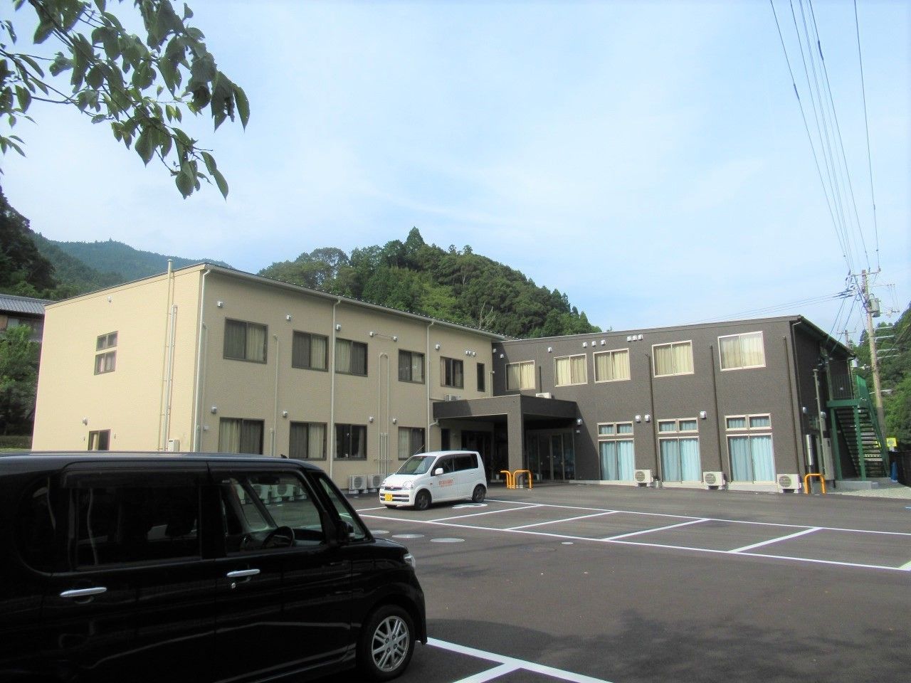 ２階建ての建物。奥がグレー、手前がベージュと色が分かれている