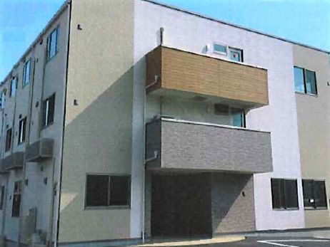 建物左部分。玄関上には屋根があり、茶系で統一された２階建ての建物。