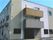 建物左部分。玄関上には屋根があり、茶系で統一された２階建ての建物。