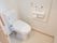 トイレは引き戸タイプの扉のあるスペースに設置されている。トイレットペーパーホルダーの下から上部にかけて手すりがついている。