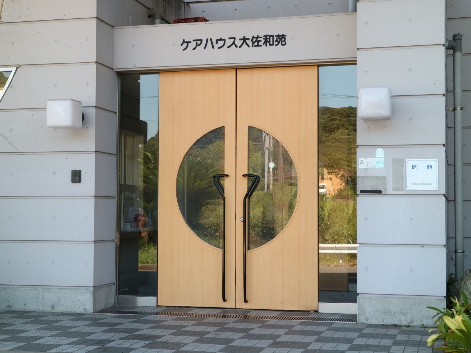 黒い大きな取っ手のついた観音開きのドアの玄関で、ガラス越しに施設の中の様子が見られるようになっている。