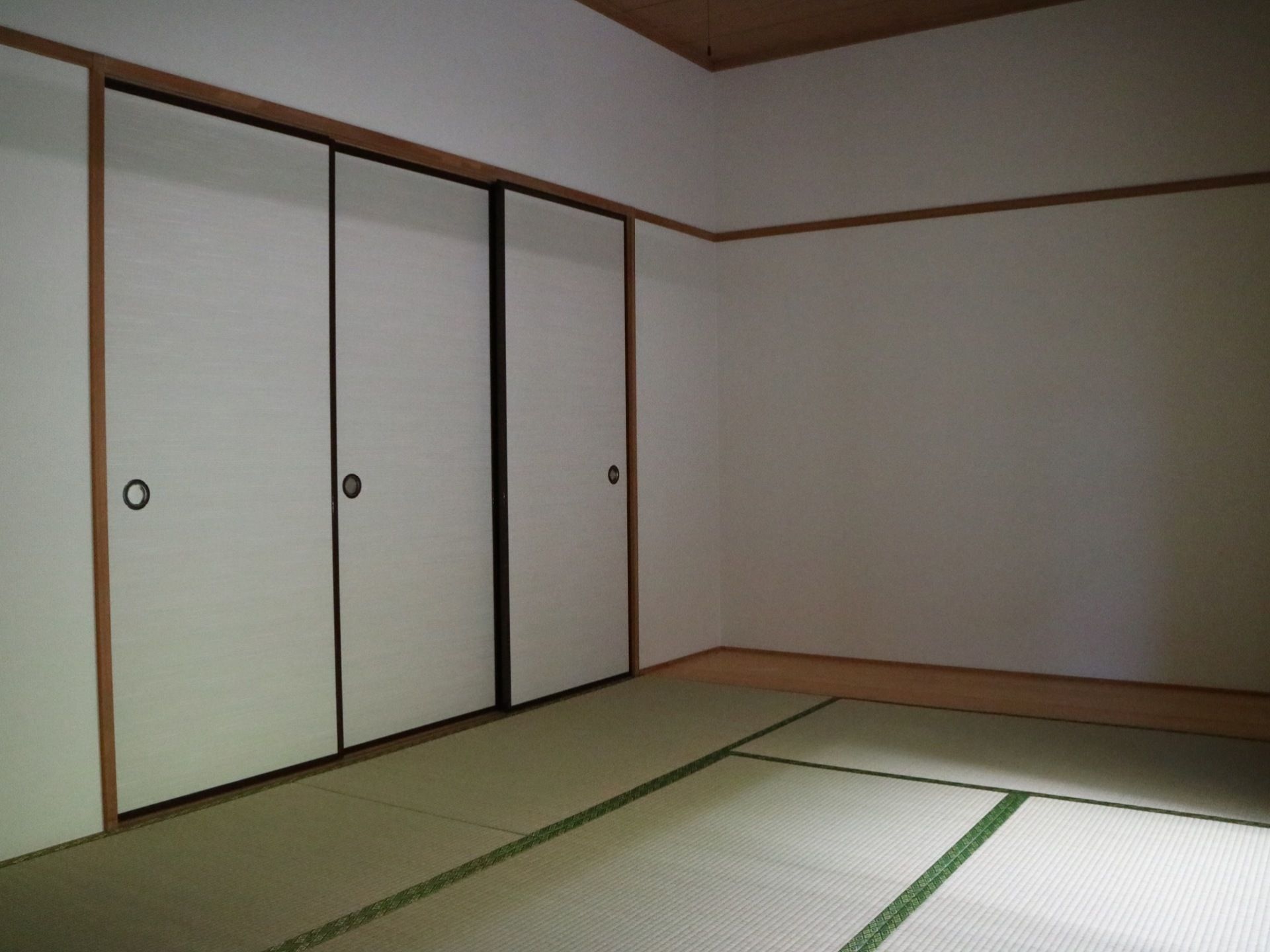 白い壁に畳が敷かれた和室の部屋で、襖も白色が使用されている。部屋の壁側の床はフローリングになっている。