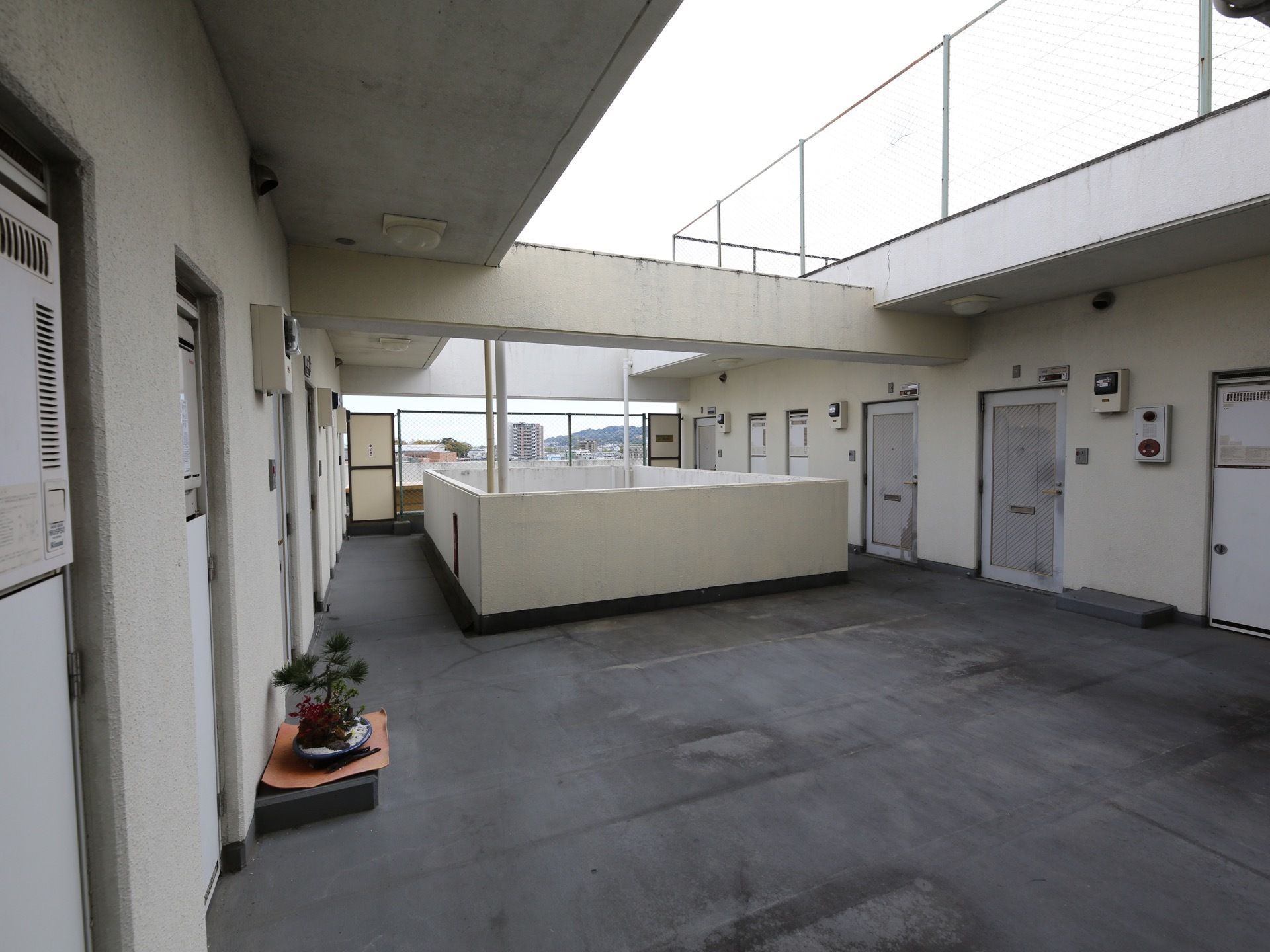 最上階は、ひさし部分以外に屋根がない構造になっている。居室の扉の近くにある台の上に、盆栽が置かれている。