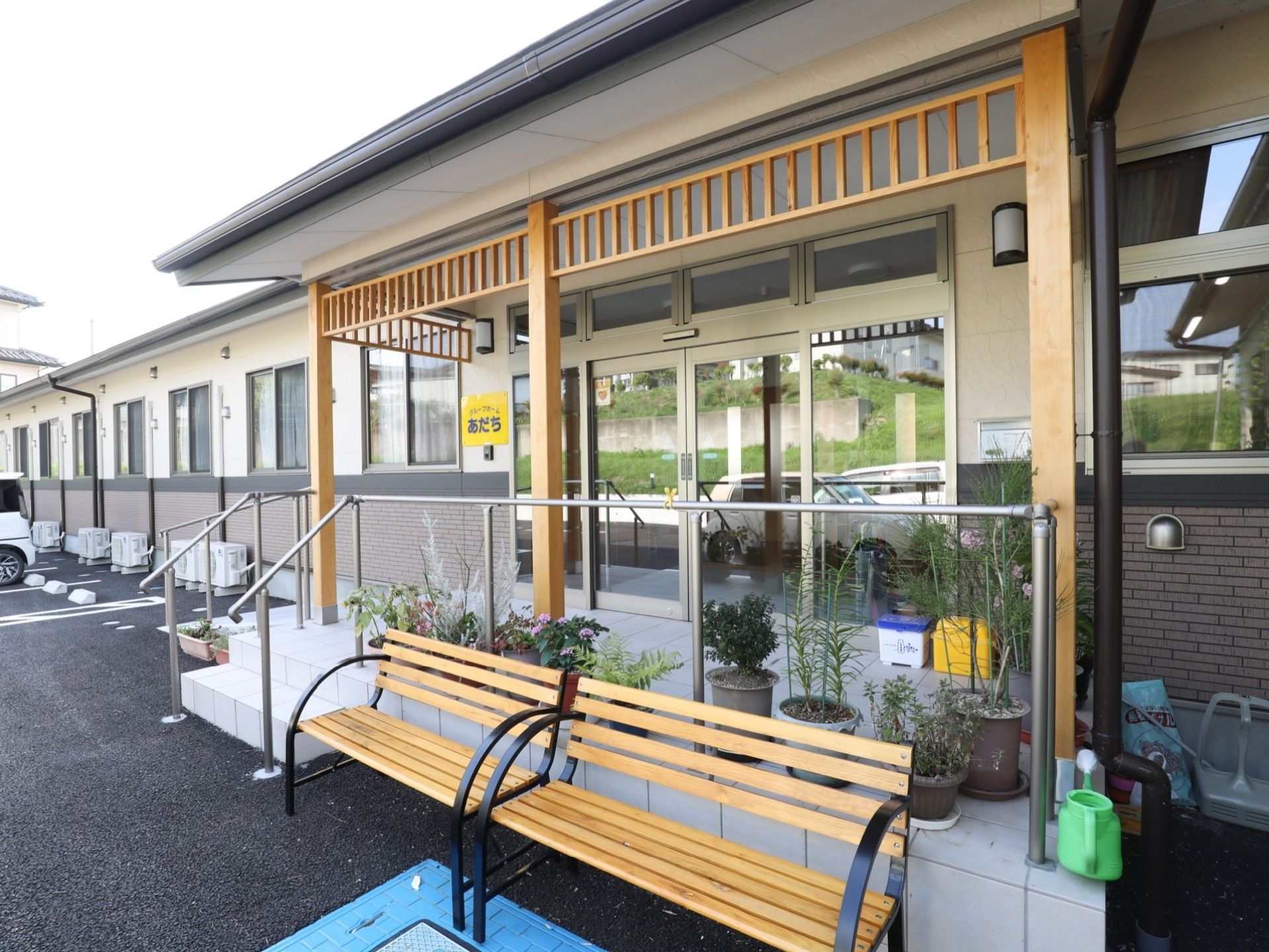 建物の入口周辺には手すりが取りつけられている。階段のほかにスロープも設置されている。また、ベンチも置かれている。