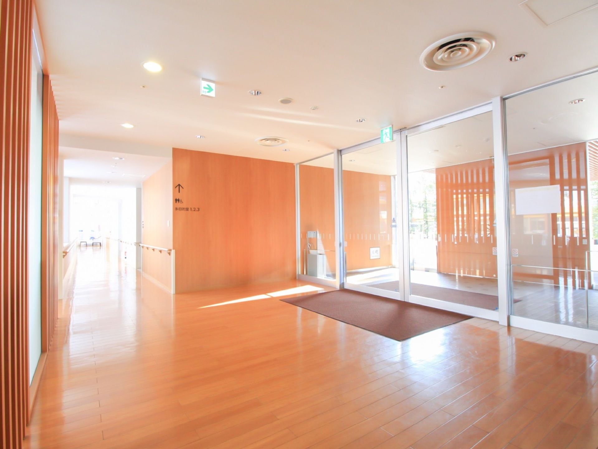 木のぬくもりが感じられる温かみのあるエントランスホール。奥には、多目的室や共用のトイレが設けられている。