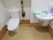 温水洗浄をはじめとした機能付きトイレの側に、転倒防止用の取手がある。また、自動水栓の手洗い場が備わっている。
