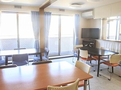 広めのスペースにテレビやいす、机がある様子。団らんできるスペース