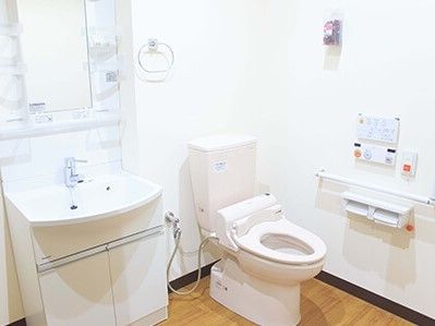 広めのスペースにトイレと洗面台がある。緊急コールが取り付けられている様子