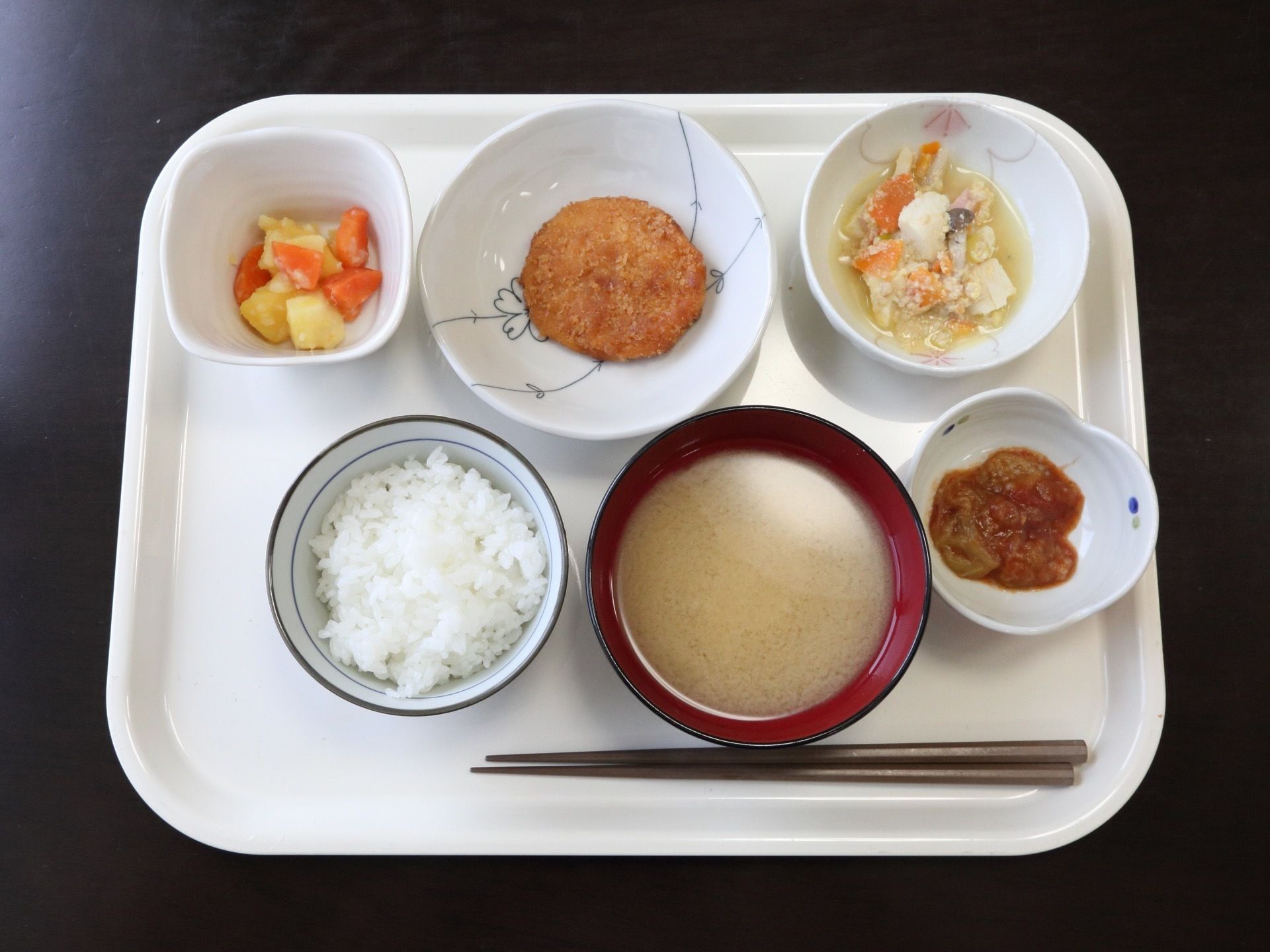 プレートに食事がのっている。ご飯、みそ汁の他、野菜やお肉も使ったおかずが４種類ある。おかずは小鉢に分けて置かれている。