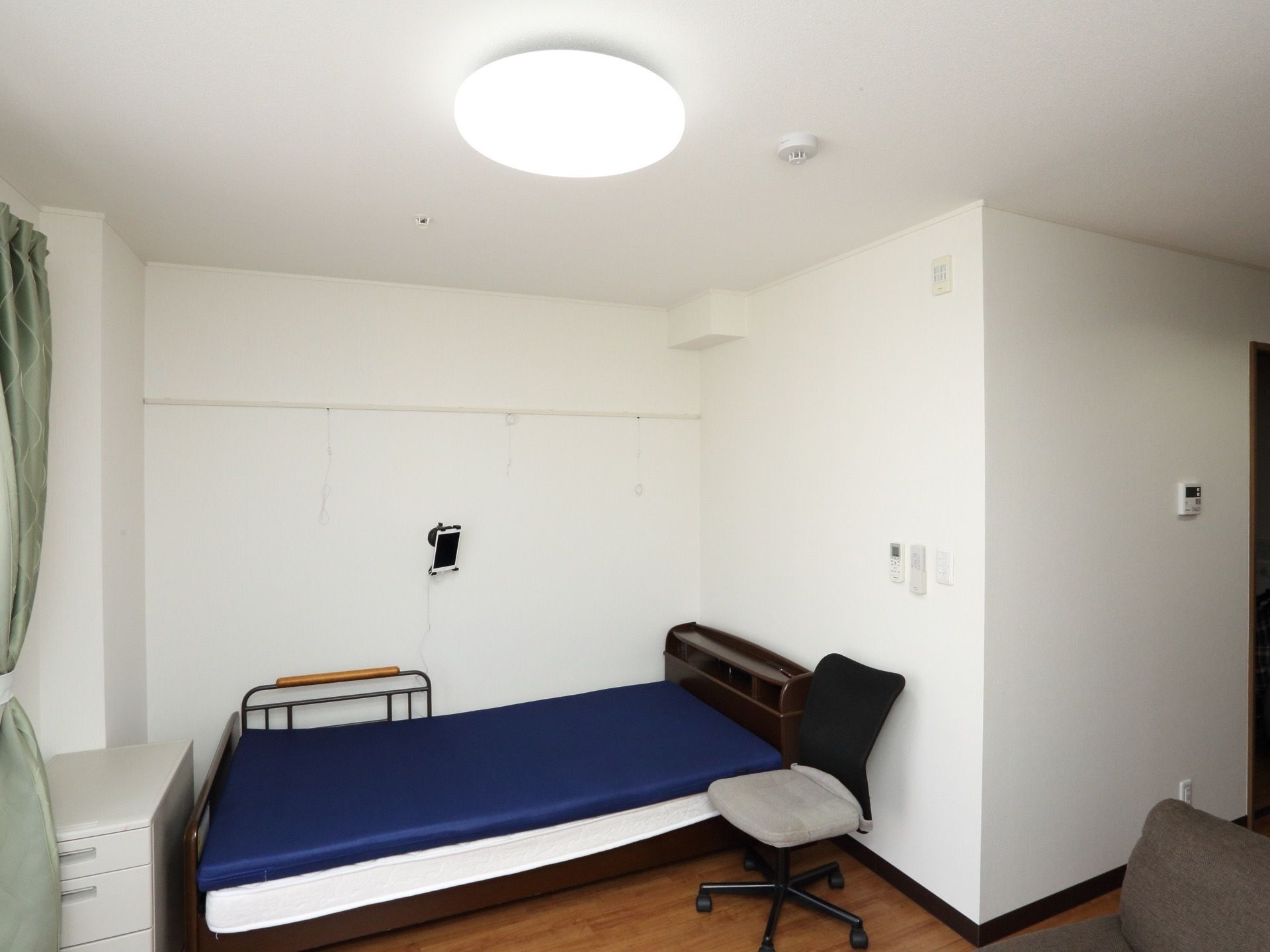 ひとりで部屋でくつろいでいる男性。ホワイトを基調とした部屋で明るい様子が分かる