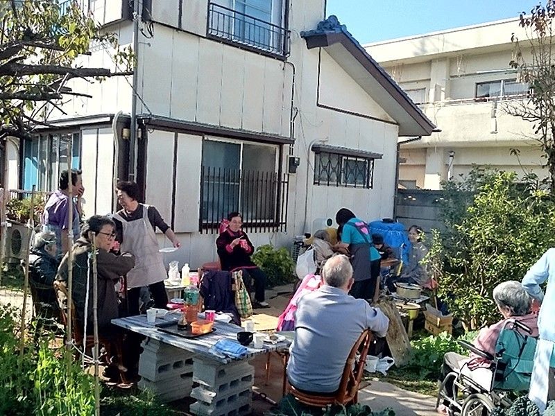 高齢者が多く集い、バーベキューのようなも暢史ものを開いている様子