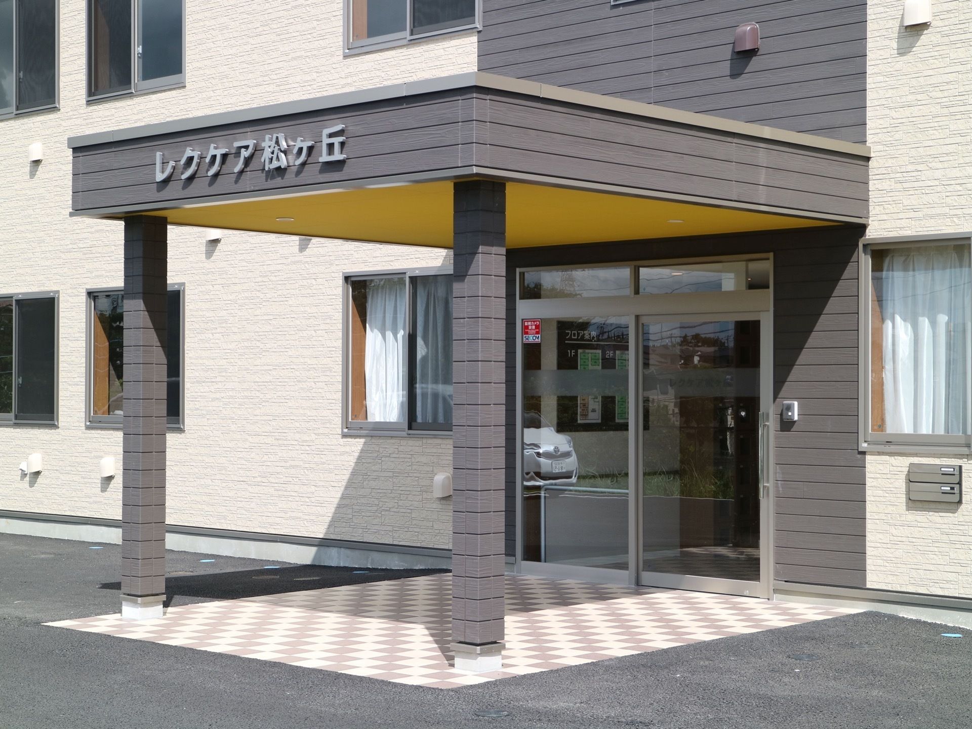 ツートンカラーが印象的な建物である。自動ドアの玄関付近には広めの軒下スペースがある。段差のない造りになっている。