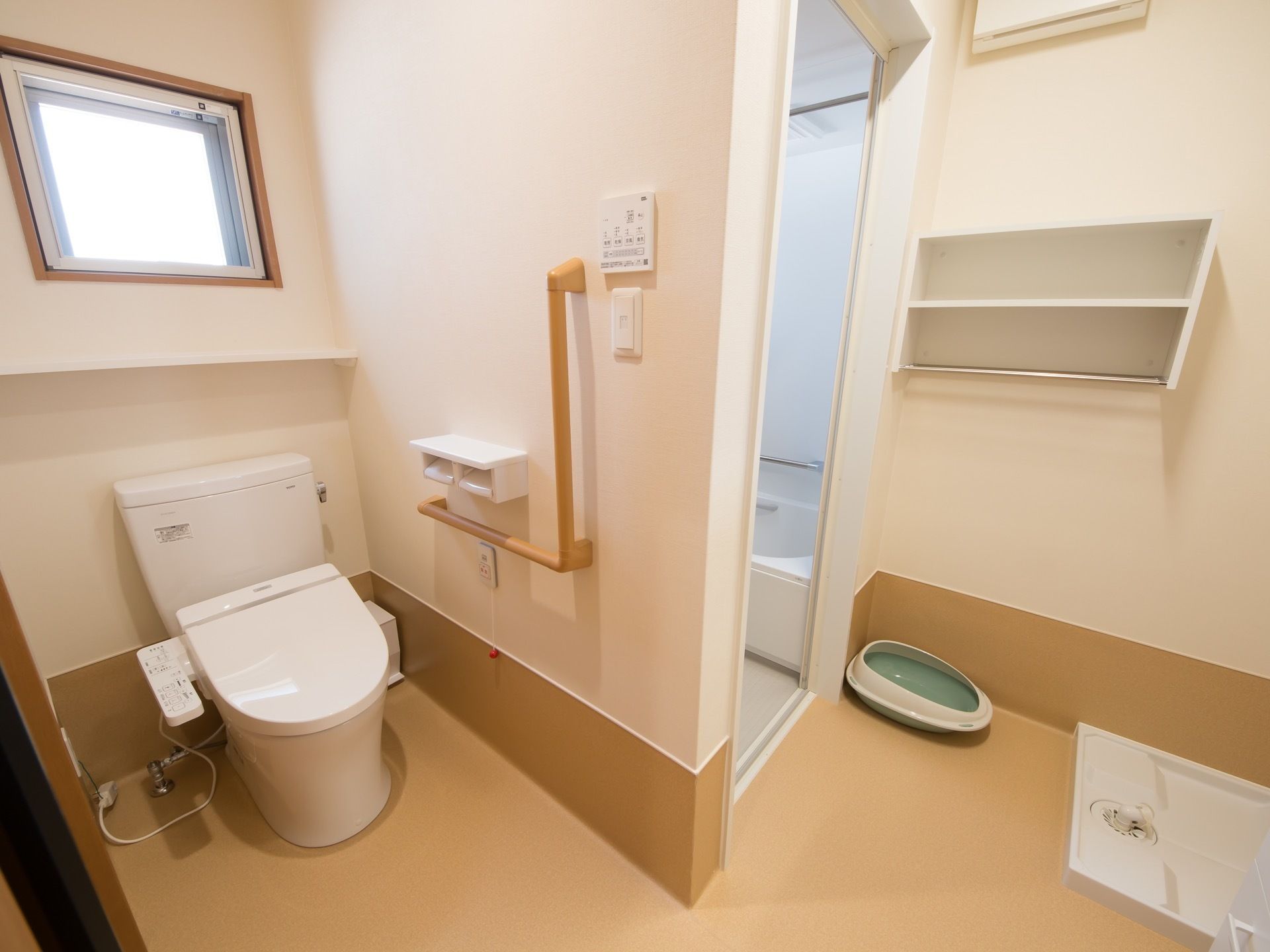 居室内の浴室の隣にトイレが備えつけられており、便器には便座カバーが付属している。便器横の壁には手すりやつかまり用の棒が備わっている。