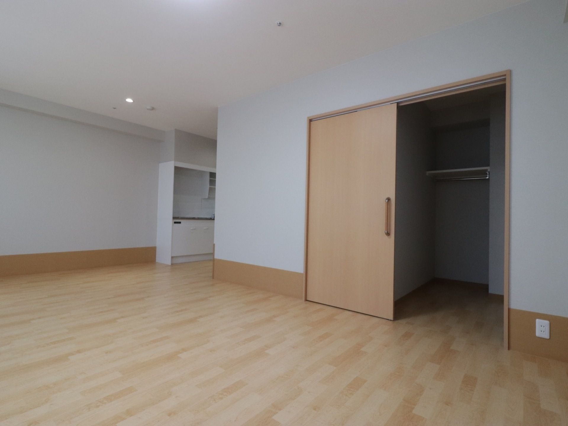 ひとりで部屋でくつろいでいる男性。ホワイトを基調とした部屋で明るい様子が分かる
