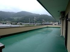 広めの施設内のベランダが写っている。曇り気味の空
