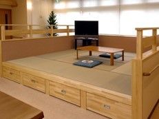 畳の小上りにテレビといすが置かれている。木の風合いが感じられる