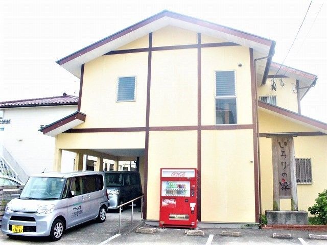 ベージュ系のホームの外観は和風で民家に近い雰囲気。ホームの前には自動販売機が置かれている。
