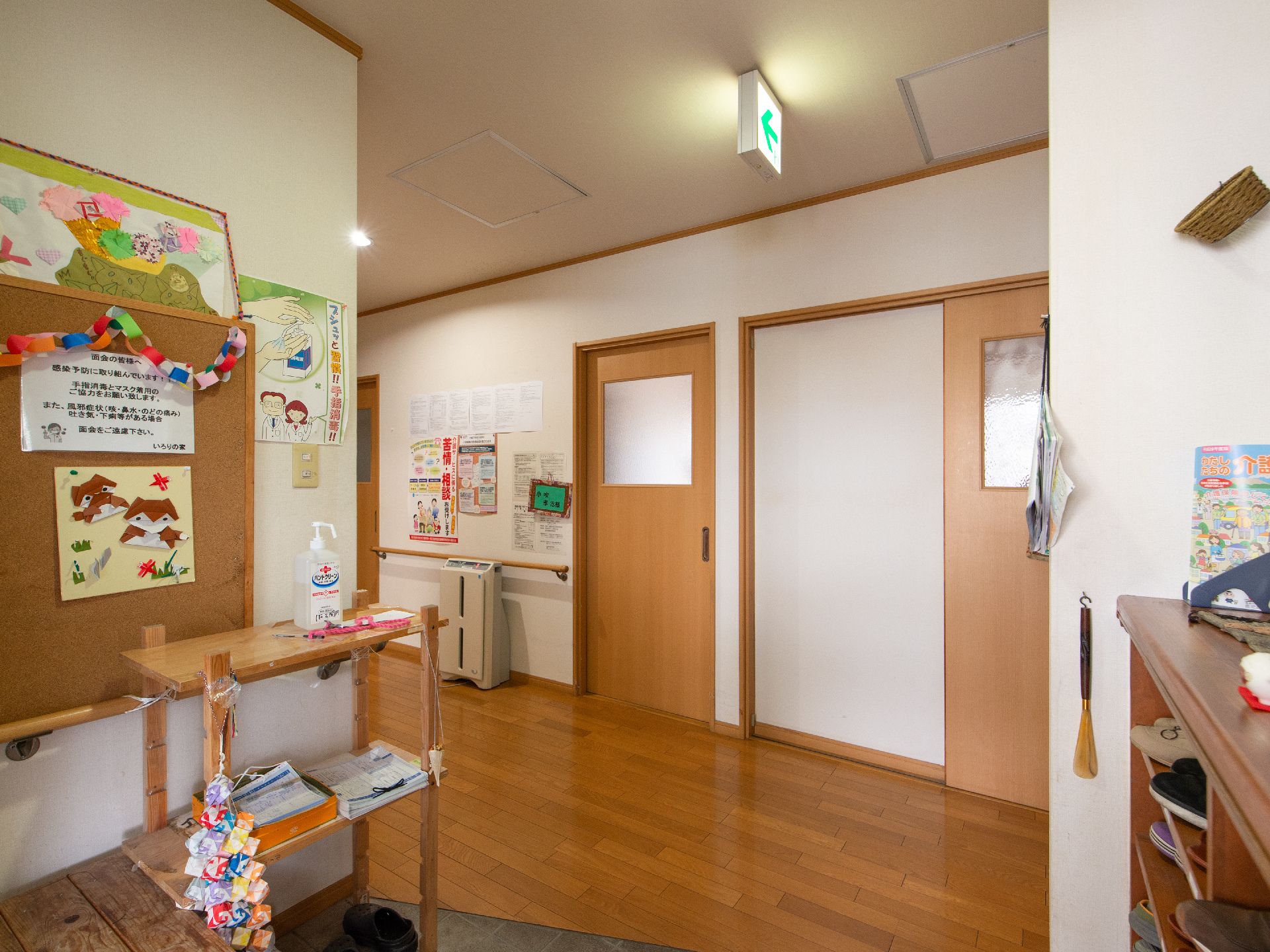 玄関の棚には消毒スプレーが設置されている。手指の消毒をしてから施設内に入ることができる。廊下には空気清浄機が置かれている。
