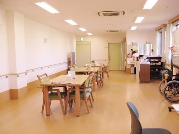 壁に手すりが取り付けてある共有スペースらしき空間。いすや机が見える